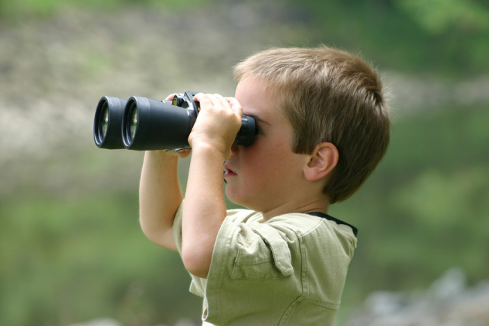 boy-looking-through-binoculars-kendalwood-montessori-elementary